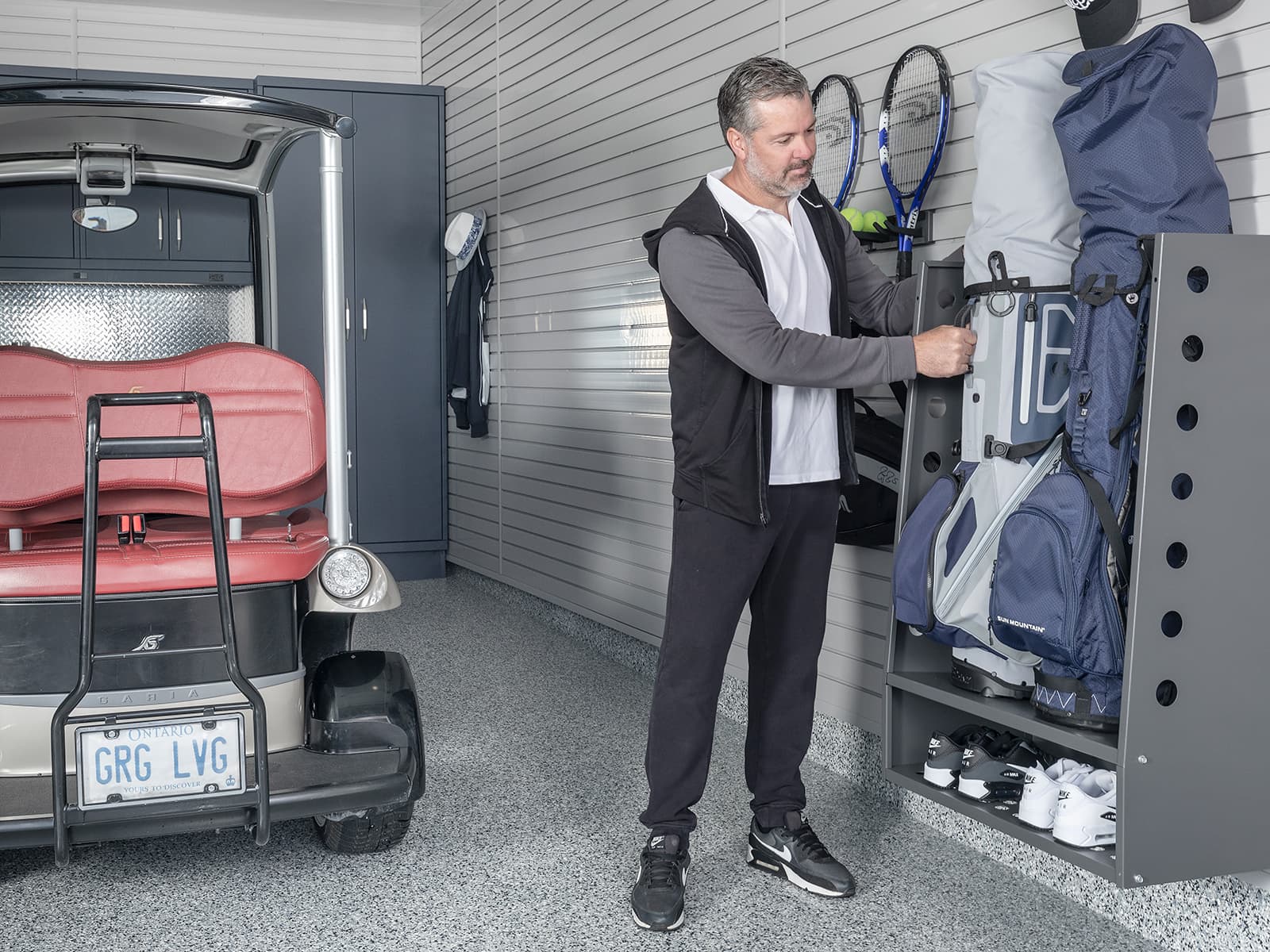 Slatwall garage storage system featuring a Linea golf caddy for organizing sports equipment - Garage Living