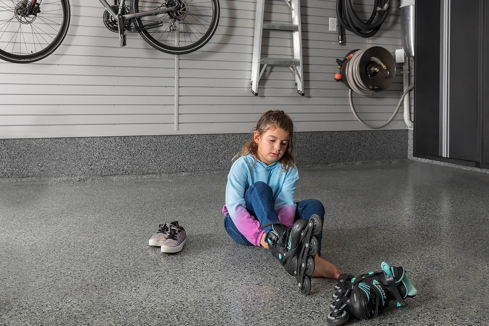 kid putting on her roller blades - The Fitness Room Garage - Garage Living