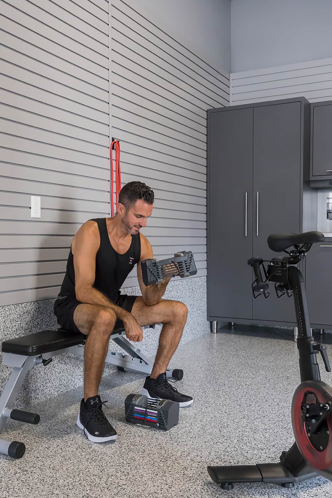 Man doling bicep curls - The Fitness Room Garage - Garage Living